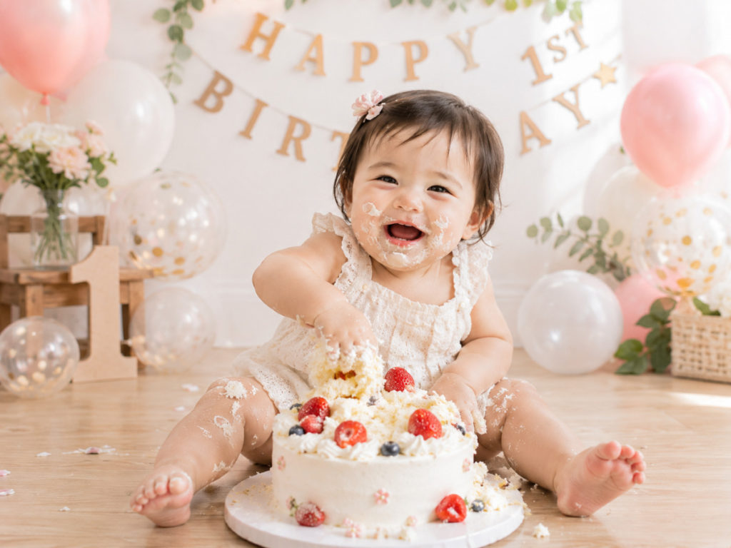 1歳の誕生日にスマッシュケーキを手づかみで楽しむ赤ちゃん